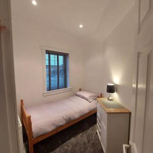 a small bedroom with a bed and a window at Crossways Cottage Quirky 2 bedroom cottage in Central location in Peebles