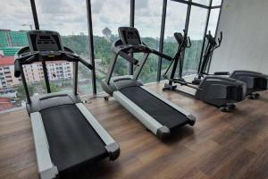 a gym with cardio machines in front of a large window at CS Homestay at Kozi Square Kuching in Kuching