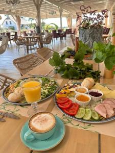 a table with plates of food and drinks on it at Hotel-Przystań in Kikół