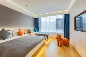 a hotel room with two beds and a teddy bear on the floor at Mount Huangshan Yunqi Kinship B&B - Huangshan Mountain Scenic Area Tangkou South Gate Interchange Center in Huangshan City