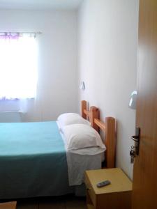 a small bedroom with a bed and a window at Hotel Celestina in Villapiana