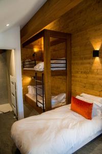 a bedroom with bunk beds in a wooden wall at Pure Montagne Resort & Spa in Saint-Martin-Vésubie