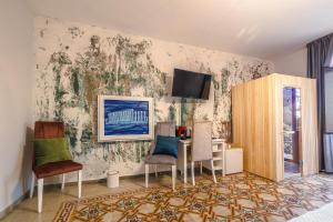 una camera con tavolo, sedie e TV a parete di BeB Omare Agrigento a Agrigento