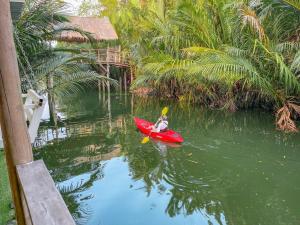 een persoon in een rode kajak in het water bij V-Relaxing Resort (Kompot) កំពត in Kampot