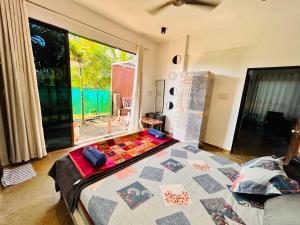 ein Schlafzimmer mit einem Bett und einem großen Fenster in der Unterkunft NzoStay Casa Cobble Luxury Villa Alibaug in Alibag