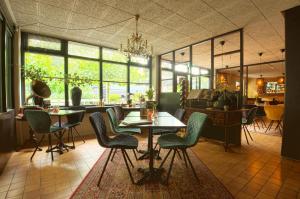 a restaurant with a table and chairs in a room at Bosrijk Ruighenrode in Lochem