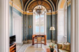 - un salon avec une chaise et une fenêtre dans l'établissement Grand Hotel Villa Serbelloni - A Legendary Hotel, à Bellagio