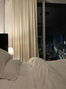 um quarto com uma cama branca e uma janela em Cozy Suite with Sky view em Riyadh