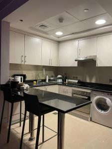 uma cozinha com uma mesa e cadeiras e uma máquina de lavar louça em Cozy Suite with Sky view em Riyadh