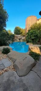 a small pond with blue water in a garden at De Zevende Hemel Guesthouse in Secunda