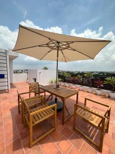 a patio with a table and chairs and an umbrella at Hut in the sky in Bangalore