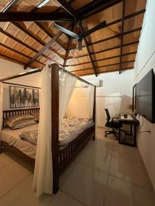 a bedroom with a bed and a desk and a tv at Hut in the sky in Bangalore