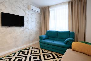 sala de estar con sofá azul y TV en Apartament Dorobanti en Bucarest