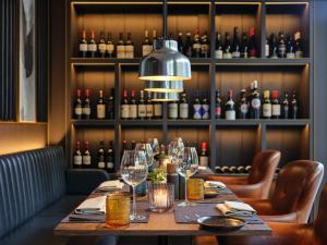 a long table in a restaurant with wine bottles at Kranz Parkhotel in Siegburg