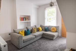 a living room with a gray couch with yellow pillows at Harbour Heights in Folkestone