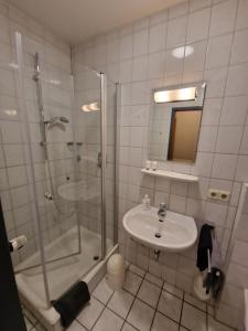 uma casa de banho com um chuveiro e um lavatório. em Gasthaus Pension DÖRENKRUG - Restaurant em Augustdorf