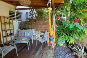 une terrasse couverte avec un hamac, des chaises et des plantes dans l'établissement Studio à la campagne, L'Aqua verde, au Gosier