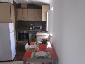 a small kitchen with a table with plates on it at Casinha da Pedra in Tomar