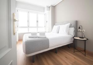 a bedroom with a large white bed with a window at Apartamento AN Sol “Ferrol” in Ferrol