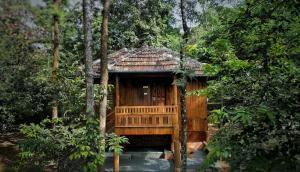 een houten huisje midden in een bos bij Mahout Resort Wayanad - An Experiential Jungle Stay with Waterfall in Kalpatta