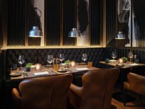 um restaurante com uma mesa longa com cadeiras e luzes em Kranz Parkhotel em Siegburg