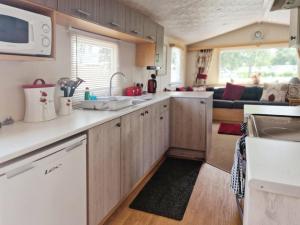 a kitchen with a sink and a counter top at Lakeside Cotswold Holiday Home in Cirencester