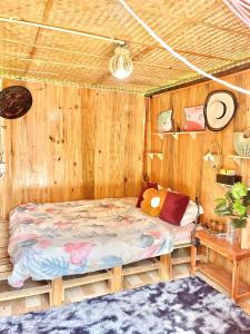 una camera con un letto su una parete in legno di Mộc Homestay Đảo Phú Quý a Cu Lao Thu