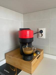 a red coffee maker sitting on a wooden stand at Dora City Apartament in Cluj-Napoca