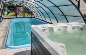 a hot tub in a greenhouse next to a swimming pool at Cozy Home In Jantar With Wi-fi in Jantar