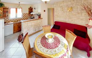 2 Bedroom Nice Home In Souvigne في Souvigné: غرفة معيشة مع طاولة وأريكة حمراء