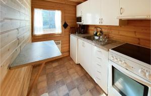 een keuken met witte kasten, een wastafel en een fornuis bij Stuga 6 in Nybro