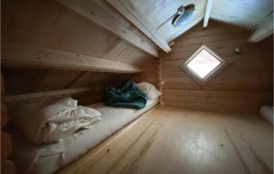 Cama en habitación de madera con ventana en Stuga 6, en Nybro