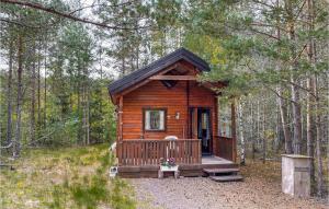 een houten hut in het bos met een veranda bij Stuga 2 in Nybro