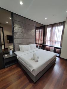 a bedroom with a large bed with two towels on it at 8 Kia Peng Suites KLCC by Luna in Kuala Lumpur