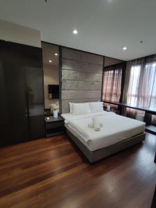 um quarto com uma grande cama branca e pisos em madeira em 8 Kia Peng Suites KLCC by Luna em Kuala Lumpur