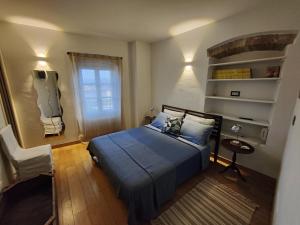 Un dormitorio con una cama azul y una ventana en Casa Etrusca, en Città di Castello