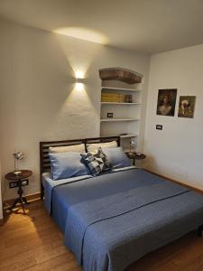 una camera da letto con letto con lenzuola e cuscini blu di Casa Etrusca a Città di Castello