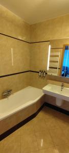 a bathroom with a bath tub and a sink at Sea Towers Apartment in Gdynia