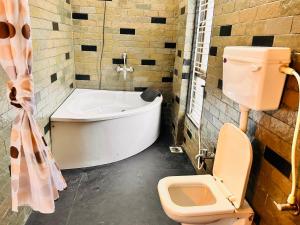 ein Bad mit einer Badewanne und einem WC in der Unterkunft NzoStay Casa Cobble Luxury Villa Alibaug in Alibag