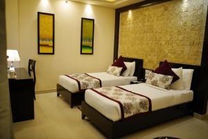 a hotel room with two beds and a table at The Vaishnavi in Deoghar