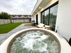 a hot tub in the backyard of a house at Klimatizovaný Apartmánový dom s vírivkou, 10A in Senec
