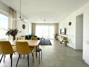 a dining room and living room with a table and chairs at Klimatizovaný Apartmánový dom s vírivkou, 10A in Senec