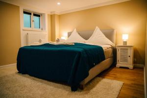 um quarto com uma cama com um cobertor azul em Riedhof 2 em Egling