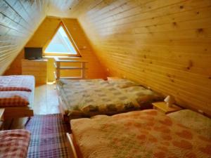 a attic room with two beds and a window at Chata Erika in Pusté Pole +14 photos