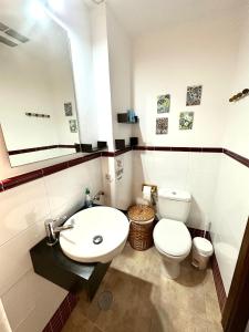 a bathroom with a white toilet and a sink at Casa De Los Baños in Cazalla de la Sierra
