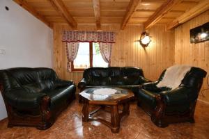 uma sala de estar com dois sofás de couro e uma mesa de centro em Chata Erika em Pusté Pole