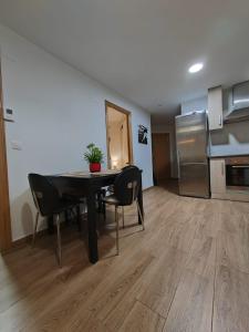 Habitación con mesa, sillas y cocina. en Loreto 6, en Albacete