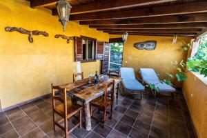 a dining room with a wooden table and blue chairs at Casa Tajonaje - Entorno rural in Alajeró