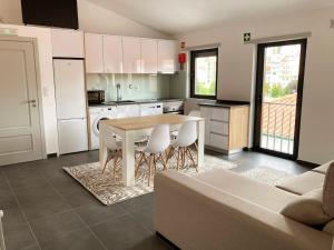 a kitchen with a table and chairs and a couch at Casa do Largo in Bragança