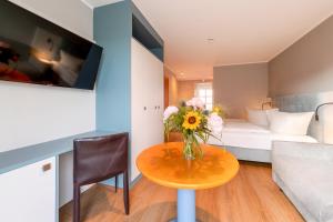 a small room with a table with flowers on it at Residenz Südwesthörn in Norderney